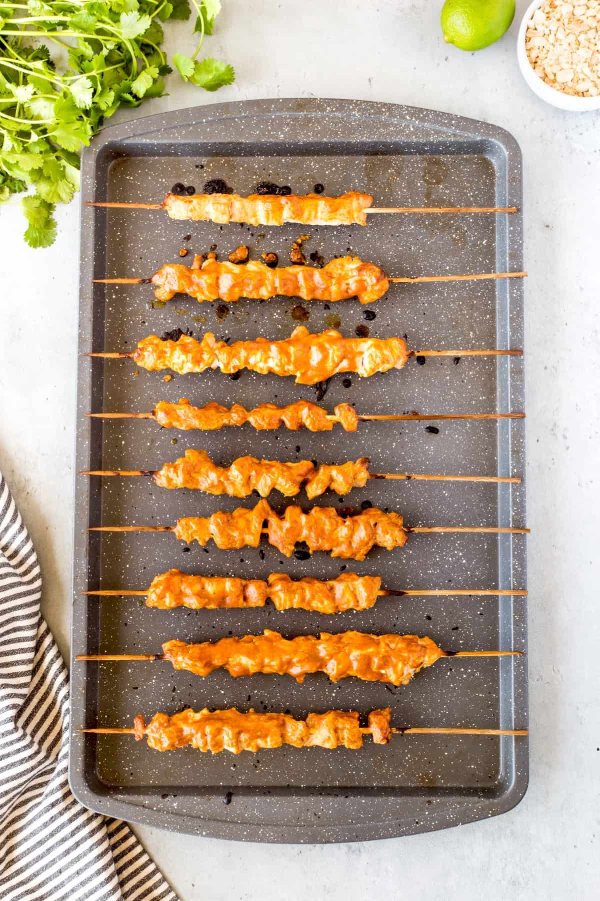 Cooked chicken satay on a baking sheet