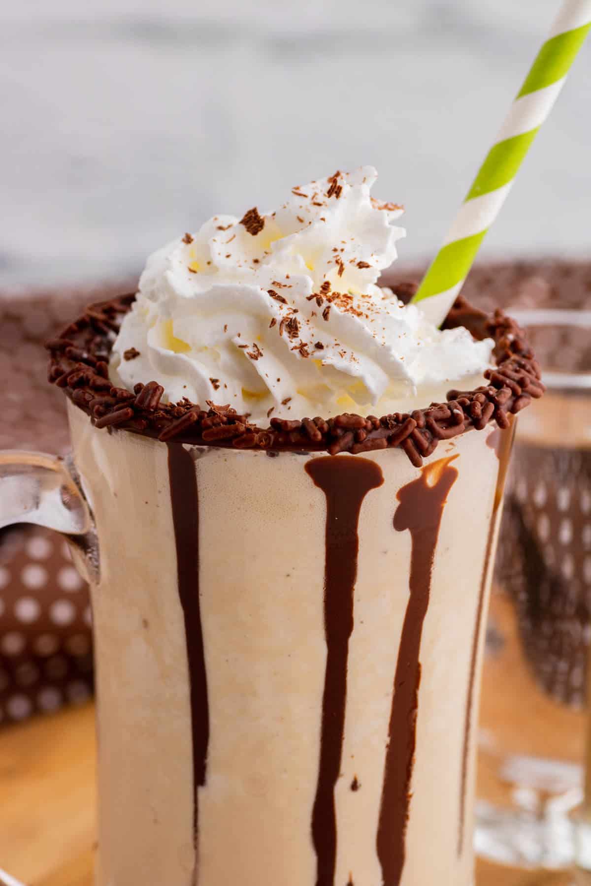 One chocolate rimmed glass mug containing frozen mudslide, whipped cream, and chocolate sauce.