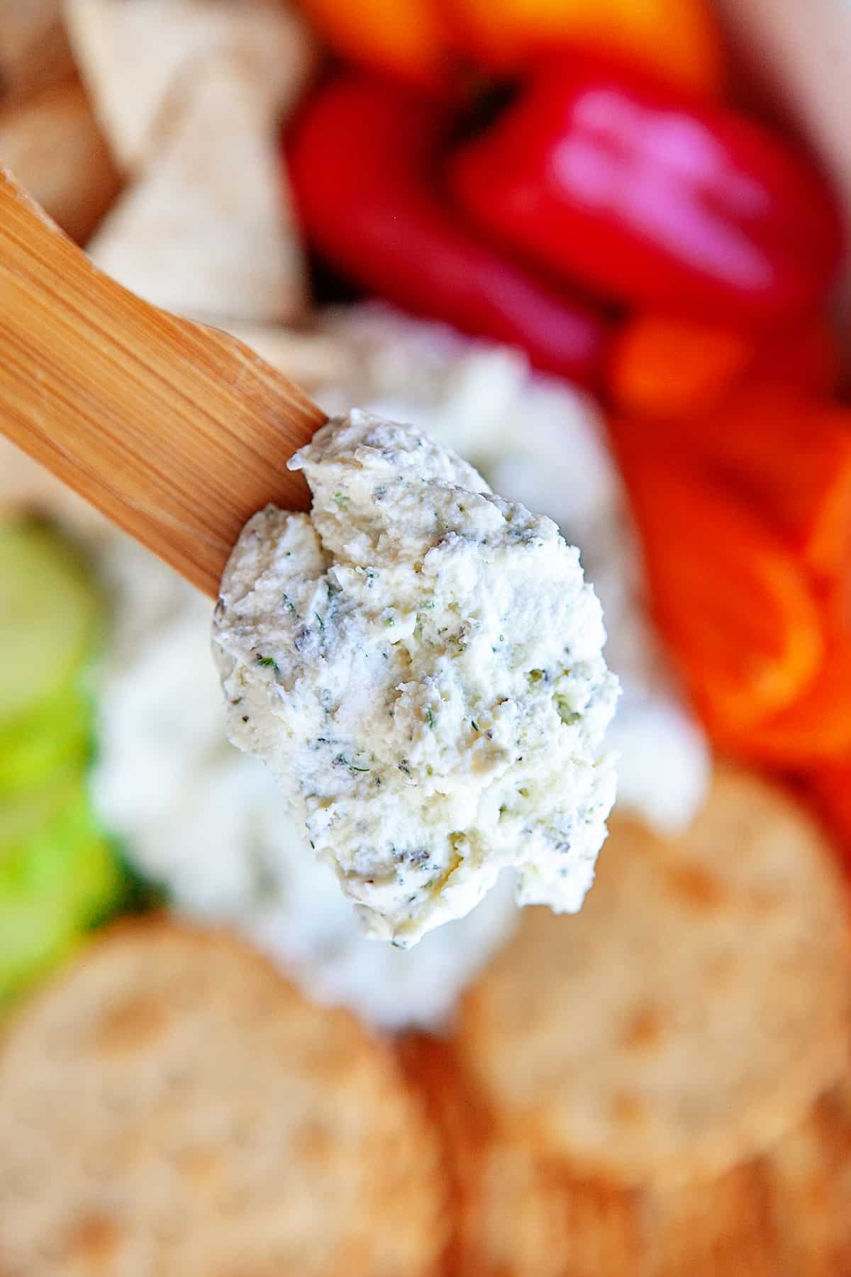 Close up of boursin cheese on a wooden spoon. 