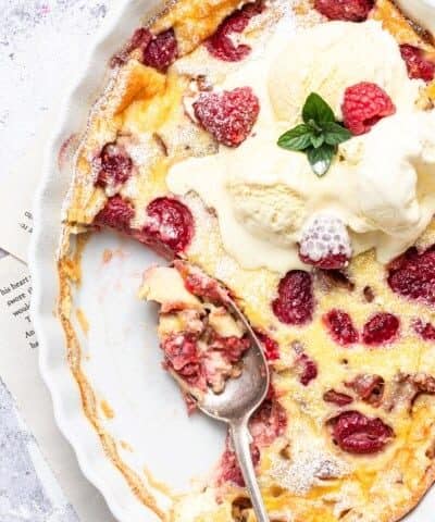 Rhubarb Raspberry Clafoutis overhead shot with ice cream and some scooped out.