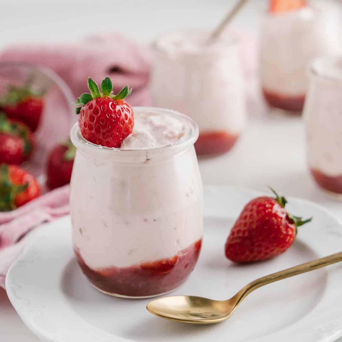 Strawberry Mousse in a jar on a plate with a spoon