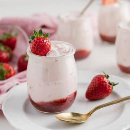 Easy Strawberry Mousse in a jar on a plate with a spoon