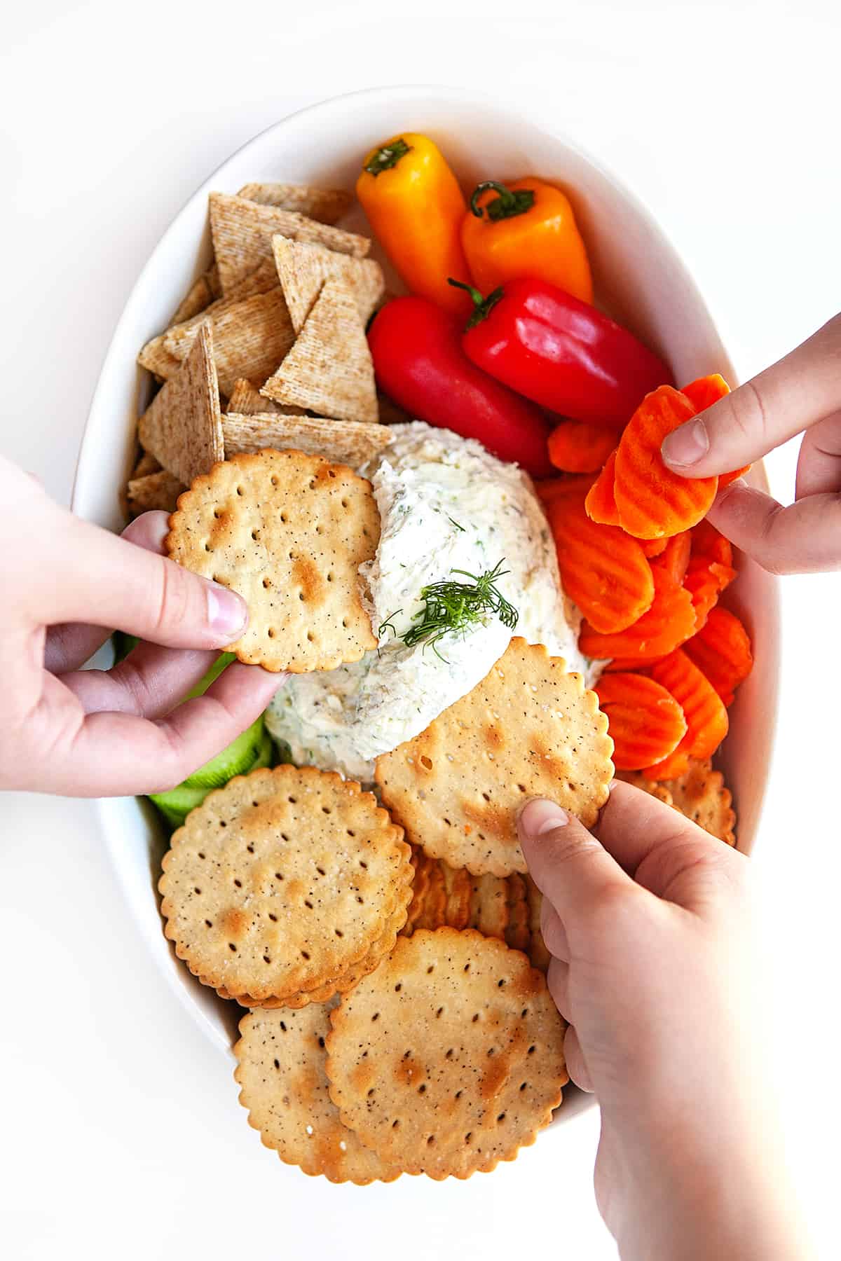 Everyone diving into a Boursin Cheese Recipe with crackers and veggies