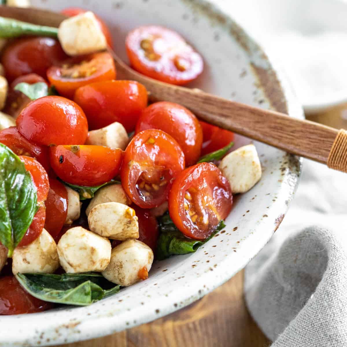 Bowl of Easy Caprese Salad with a wooden spoon