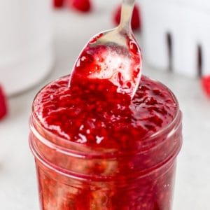 Pulling a spoon out of Easy Homemade Raspberry Sauce