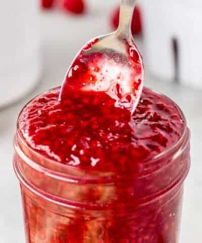 Pulling a spoon out of Easy Homemade Raspberry Sauce