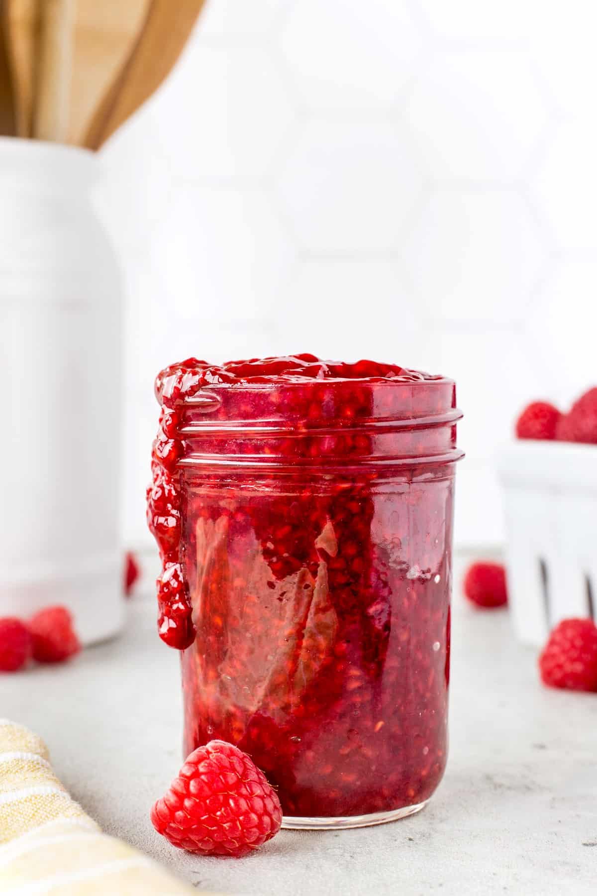 Jar of Easy Homemade Raspberry Sauce overflowing
