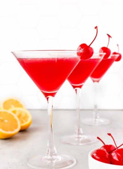 Lemon Cherry Martini with lemons and cherries in the background
