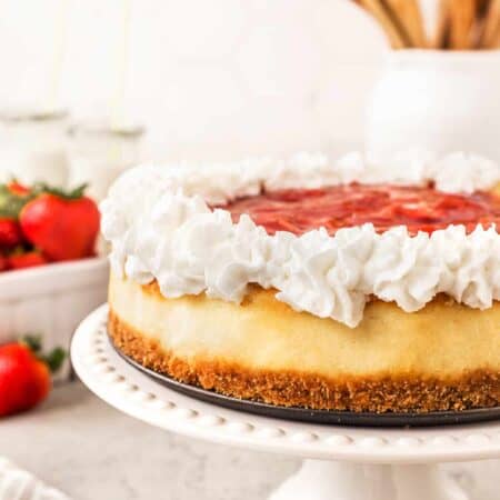 Light and Airy Strawberry Cheesecake on a cake stand.