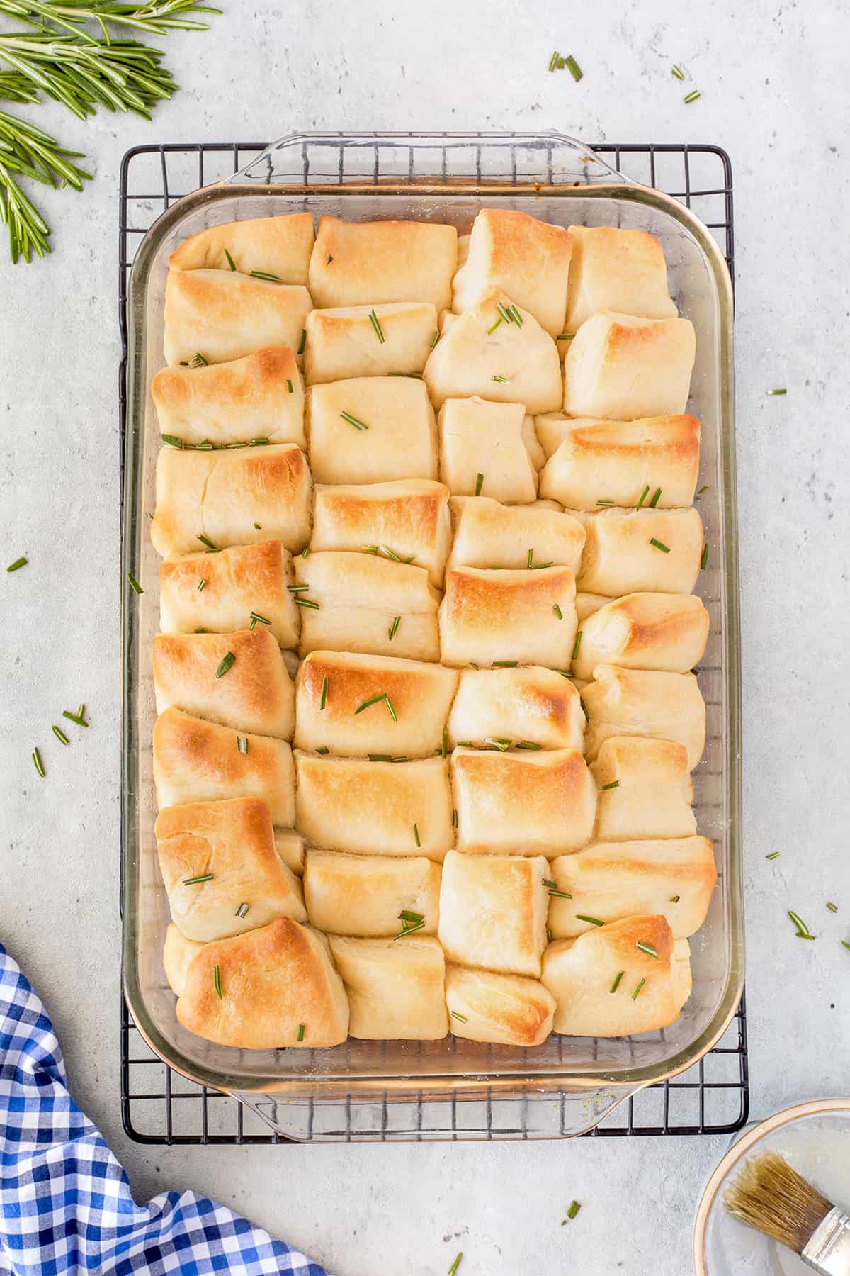 Overhead of baked rolls in a glass pan.