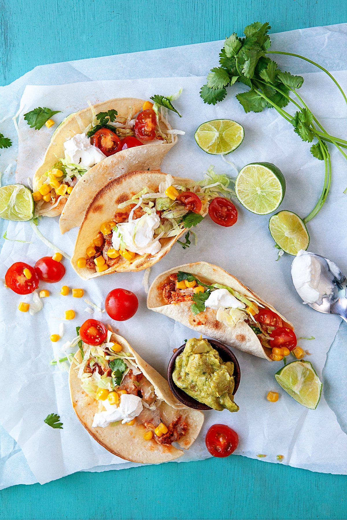 Overhead of tacos and toppings on parchment