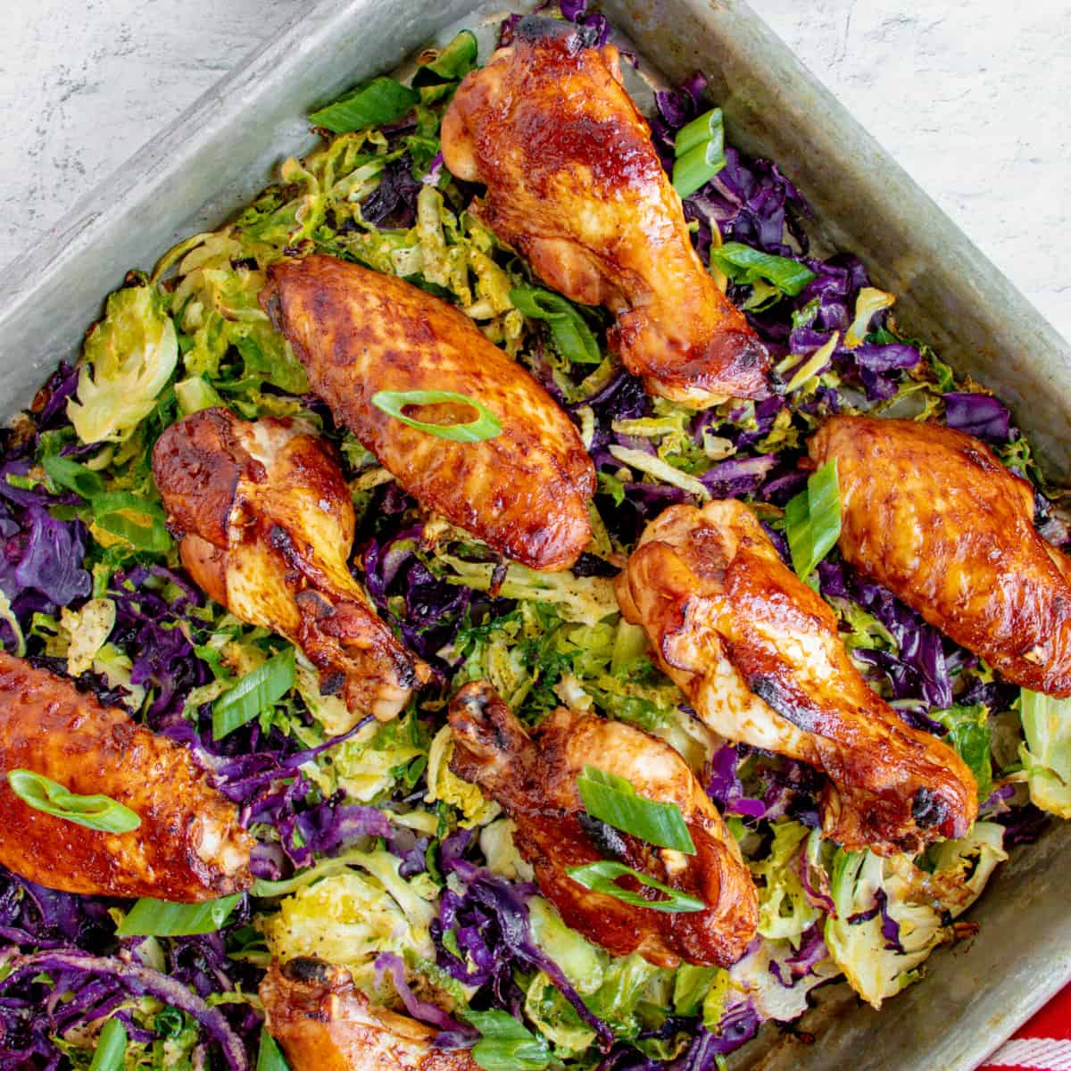 Overhead of Baked Chicken Wings on Brussels sprouts and red cabbage.