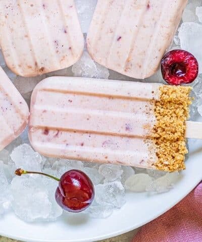 Cherry Cheesecake Popsicles on ice with cherries