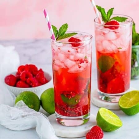 Raspberry Mojitos with limes and raspberries around