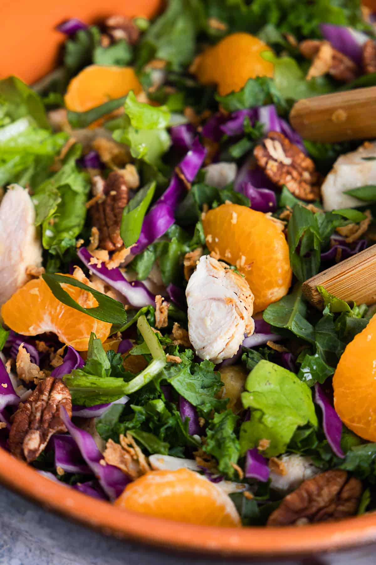 Close up of the salad featuring mandarin, chicken, red cabbage, lettuce and kale