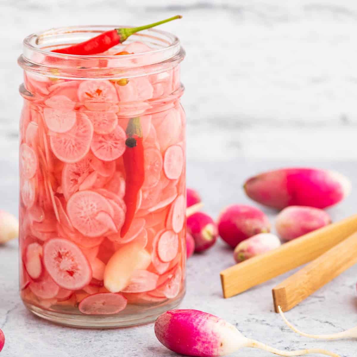 Jar of Quick Pickled Radishes with chili peppers