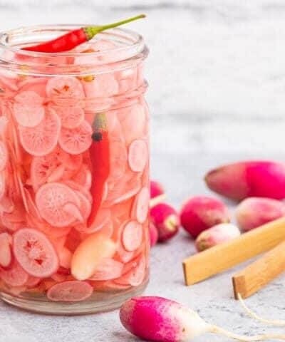 Jar of quick pickled radishes with chili peppers