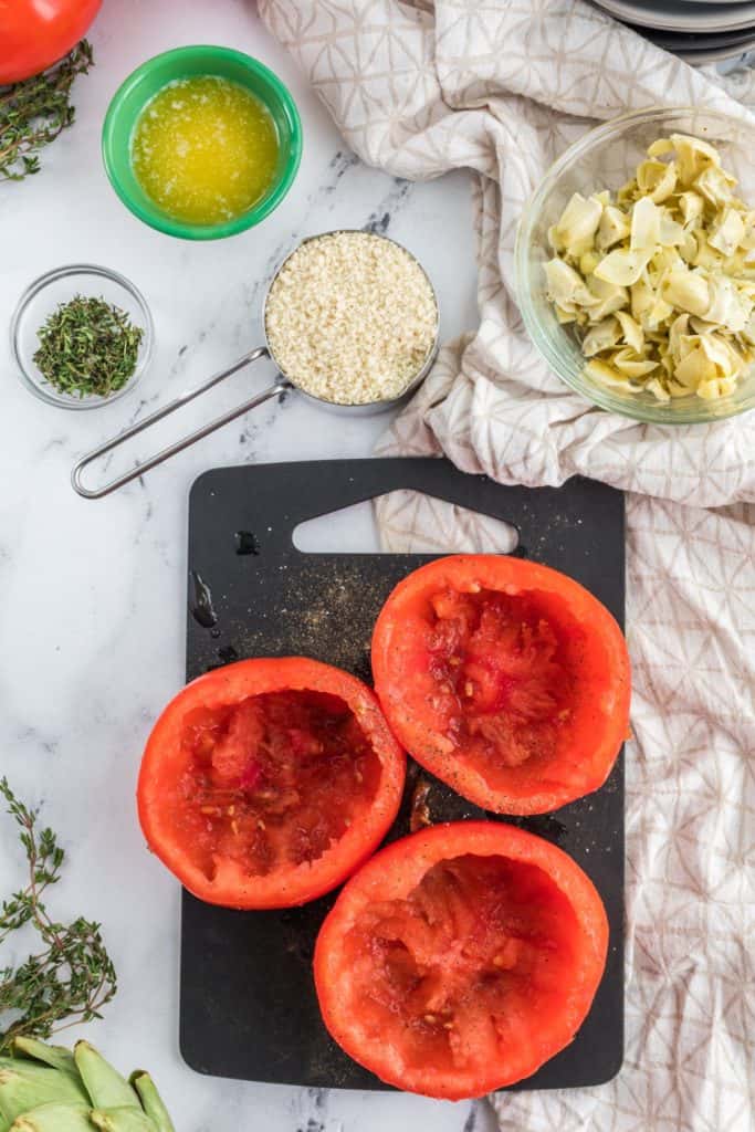 Cored out tomatoes on a board