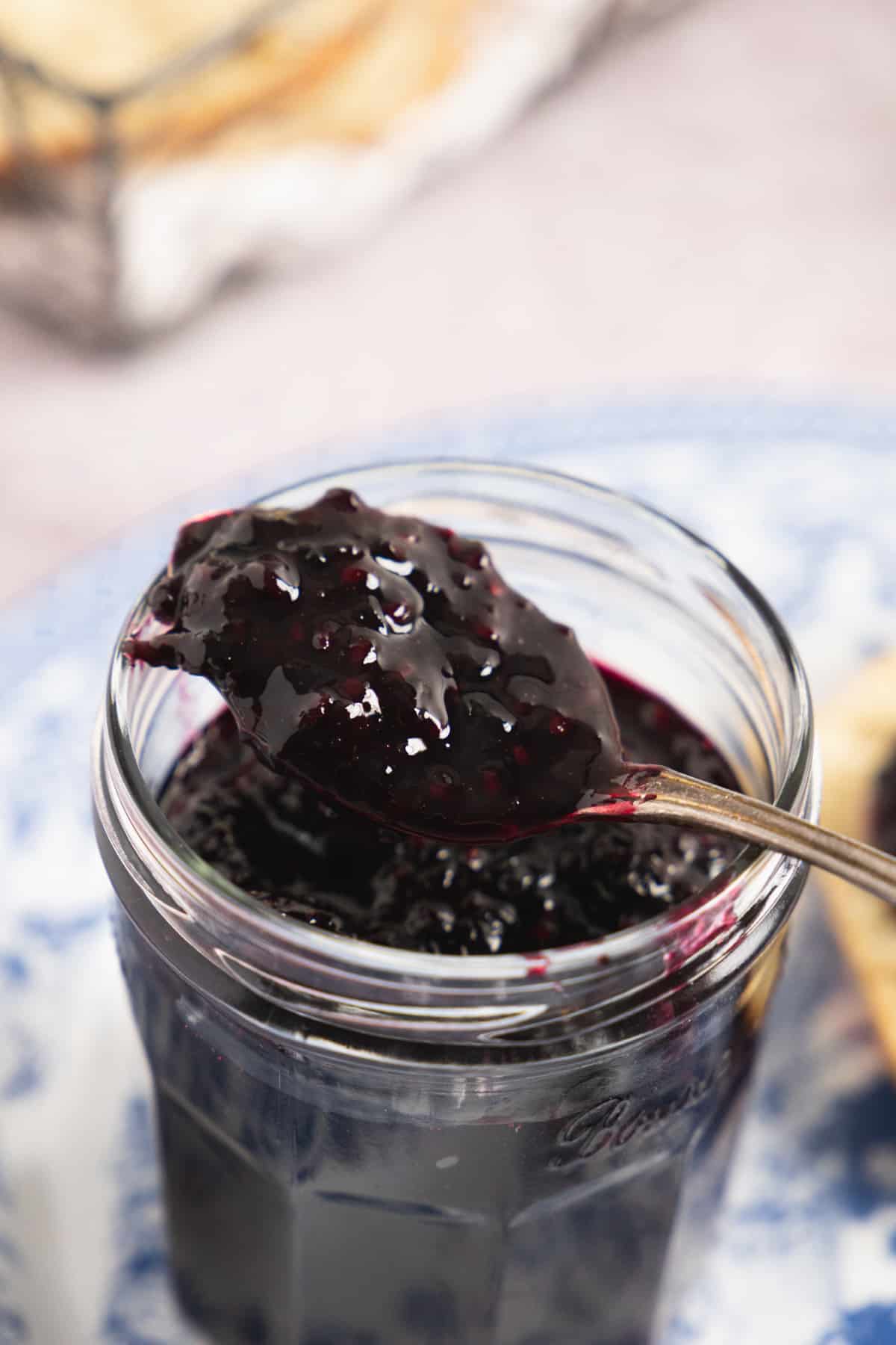 Close up of a spoon in the blackberry jam jar.