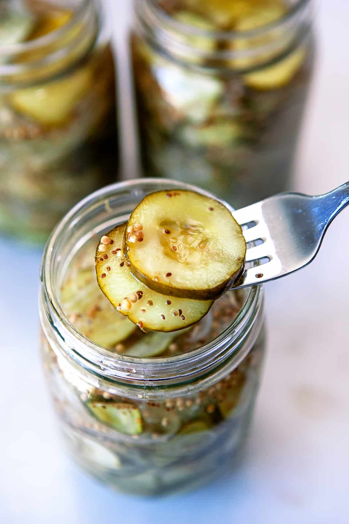 Taking pickles out of a jar with a fork.