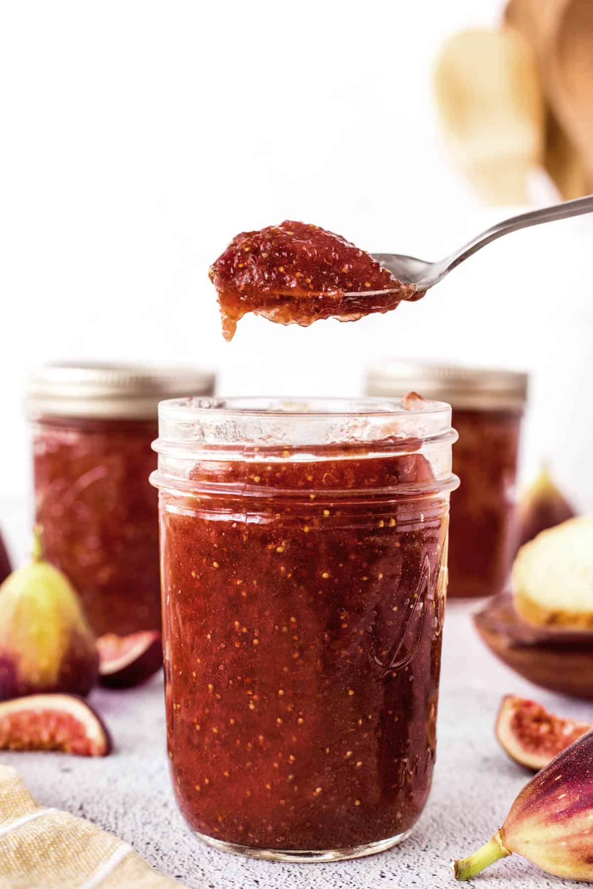 Spoonful of fig jam over a jar of fig jam