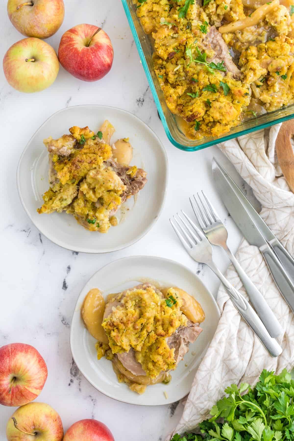 Overhead of 4 Ingredient Oven Baked Pork Chops on plates with the casserole