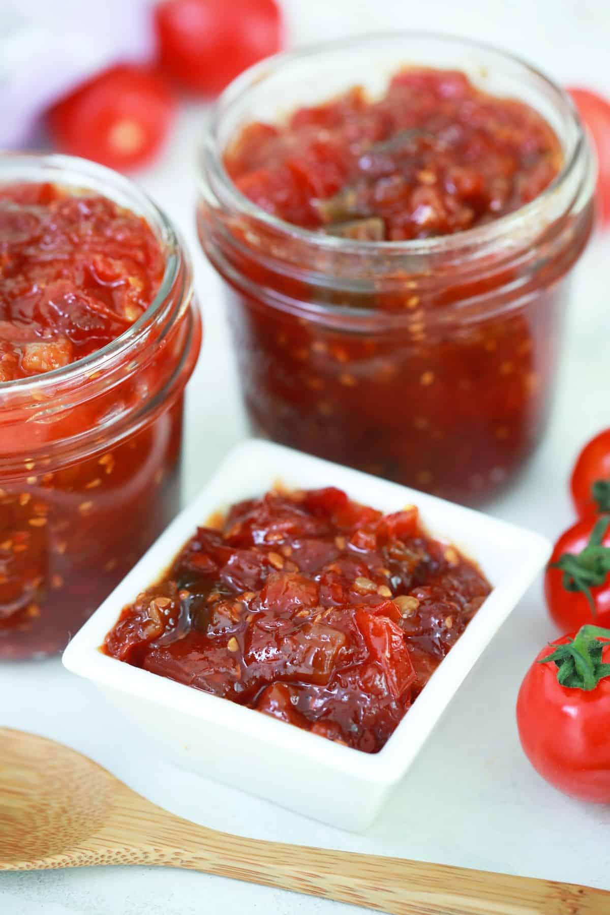 Tomato jam in jars and a small white dish