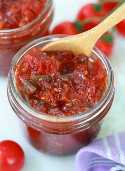 Tomato Jam in a jar with a wooden spoon