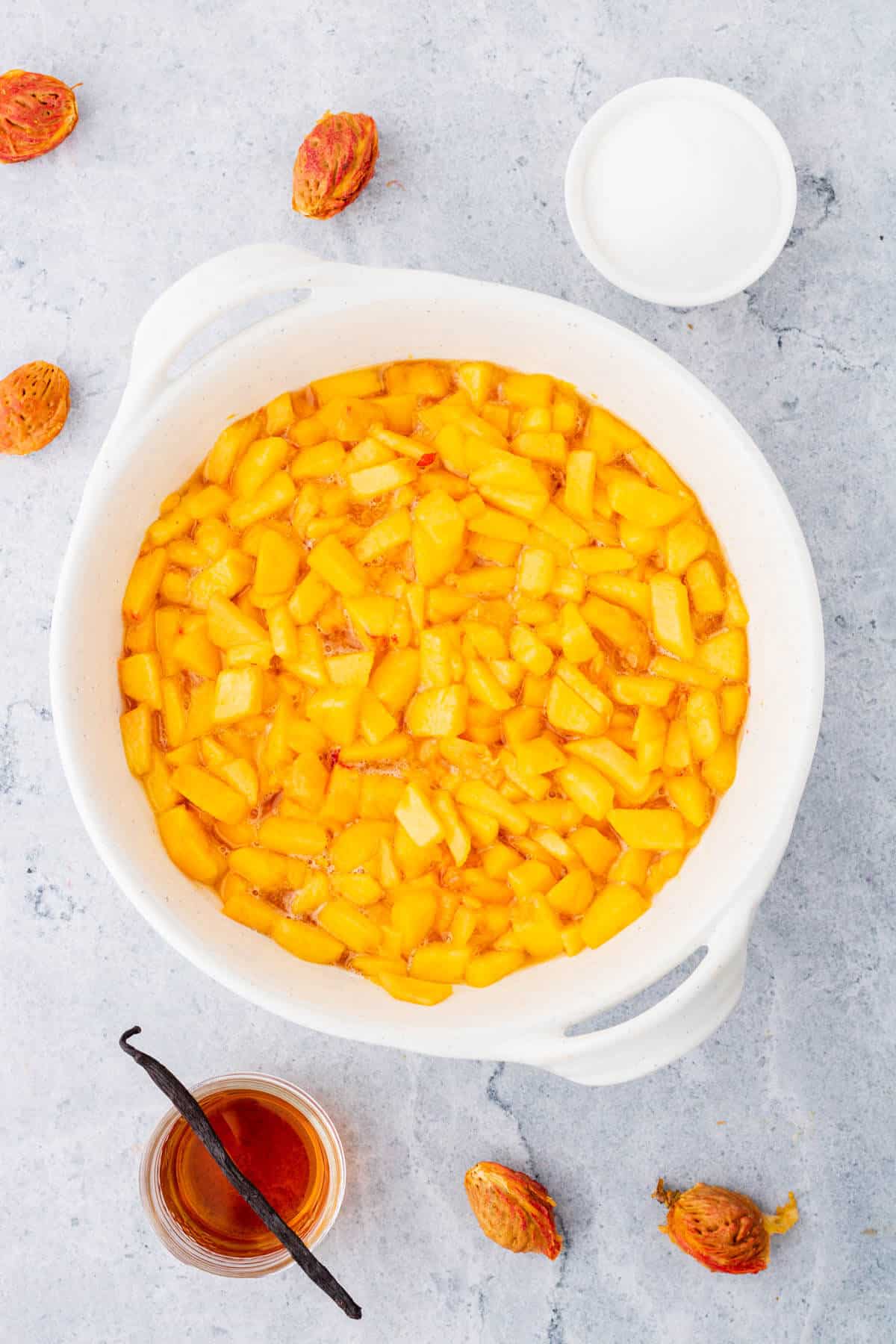 A white bowl containing chopped macerated peaches.