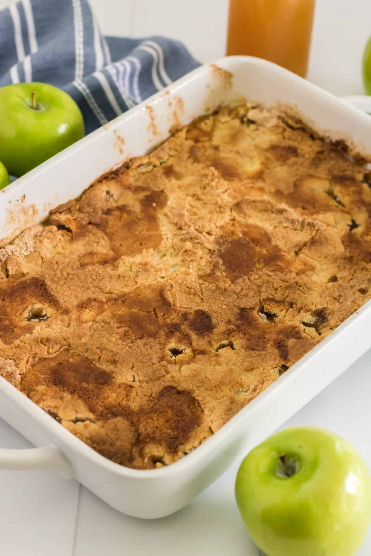 Apple dump cake in a white pan fresh out of the oven. 