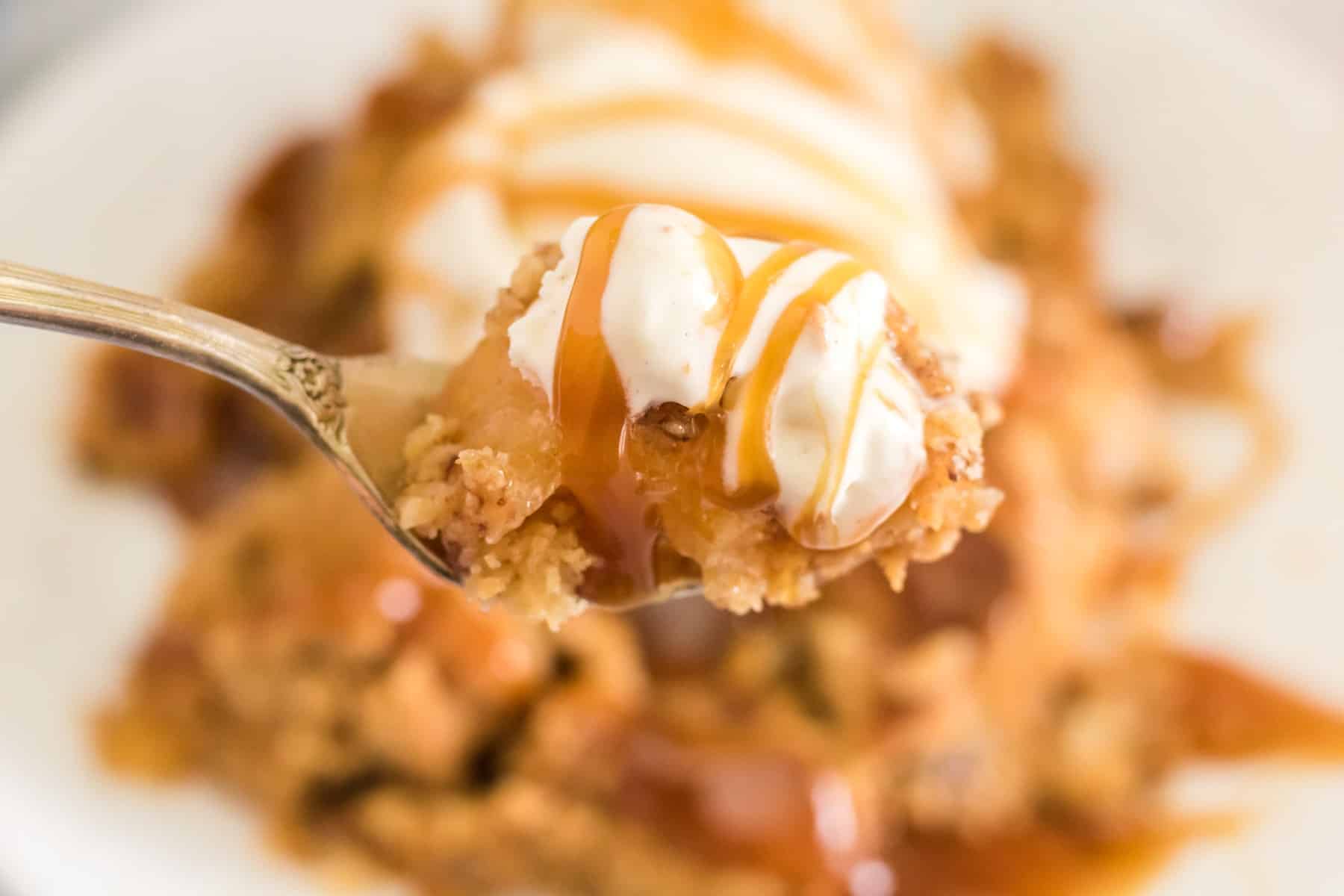 Forkful of apple dump cake with ice cream and caramel sauce