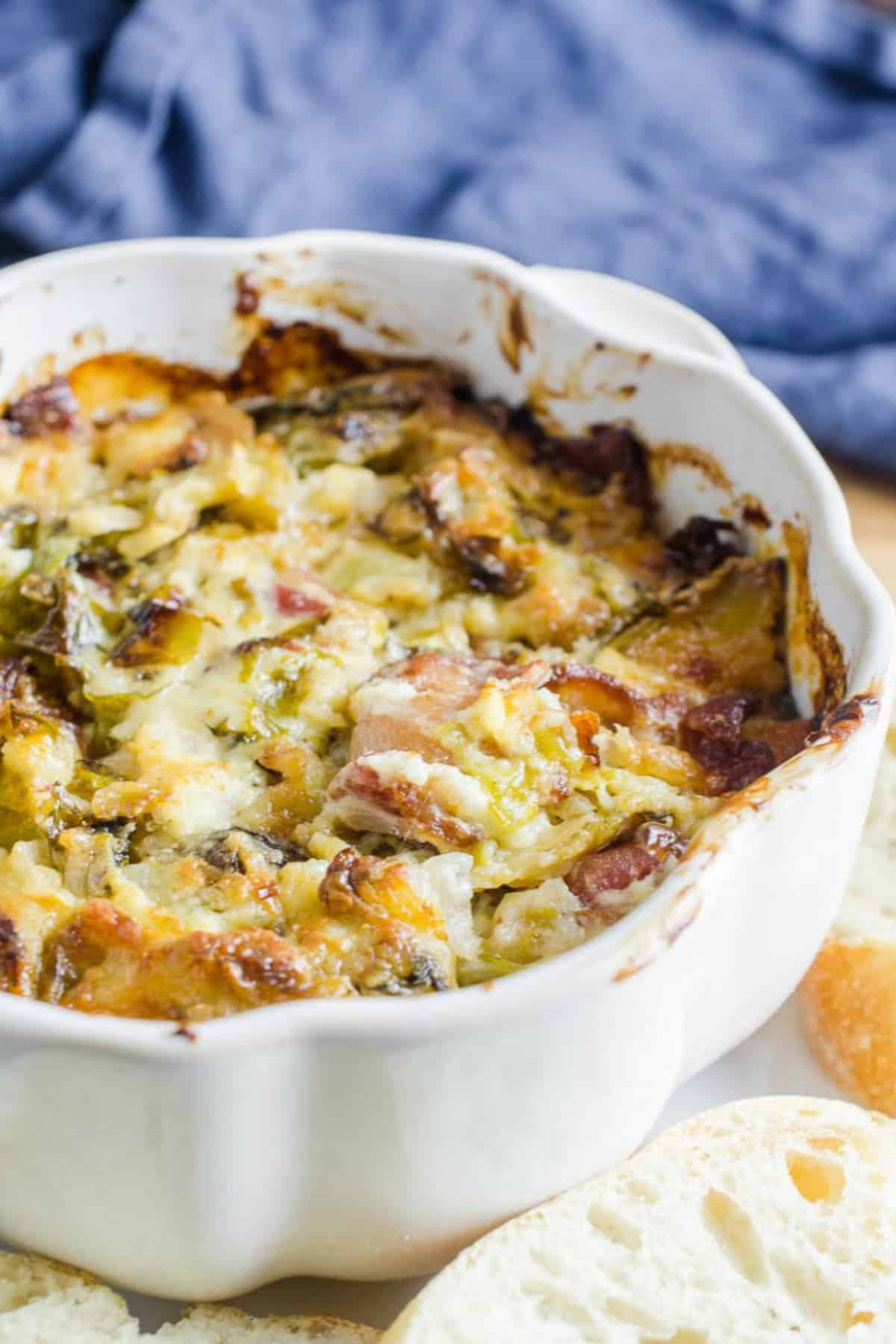 Cheesy Brussels Sprouts Dip in a white bowl. 