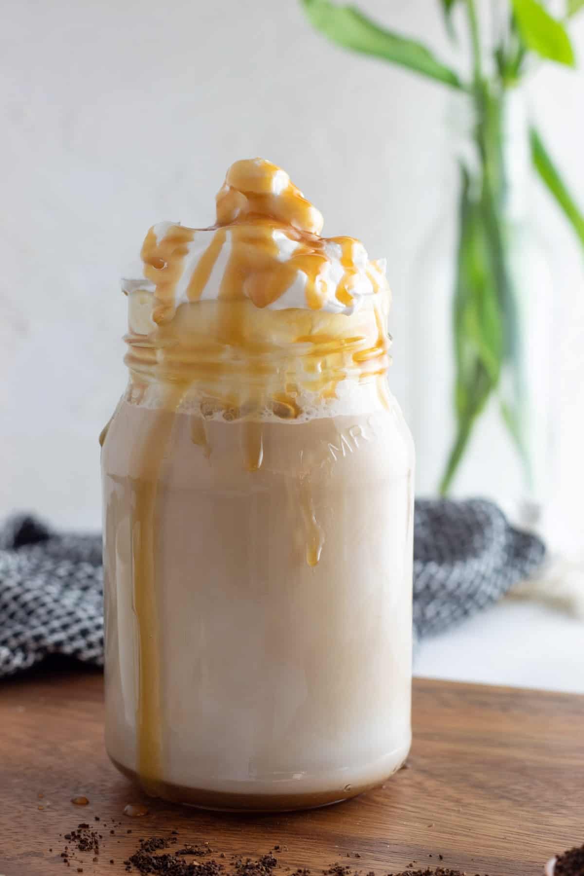 Copycat Starbucks Caramel Macchiato in a jar topped with whipped cream and caramel. 