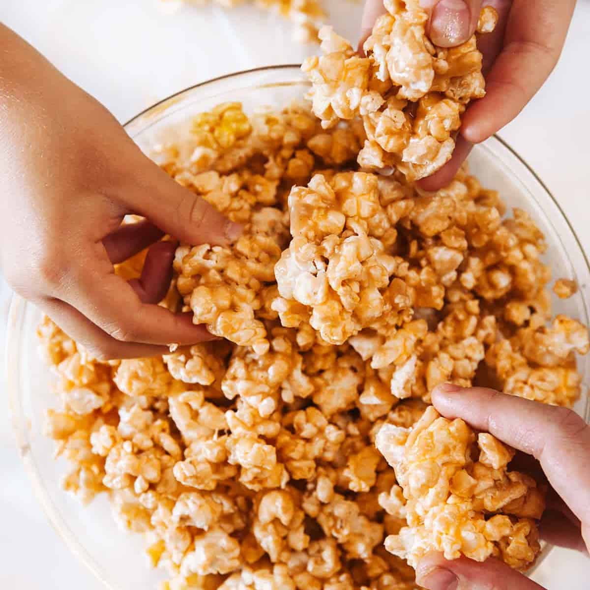 Grabbing peanut butter popcorn from a bowl. 