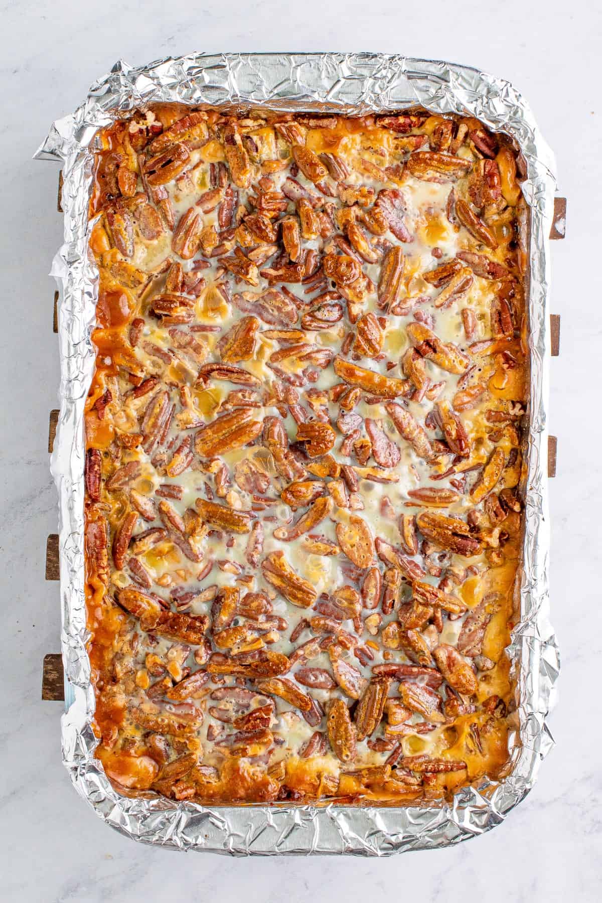 Overhead of pumpkin bars in a foil lined pan. 