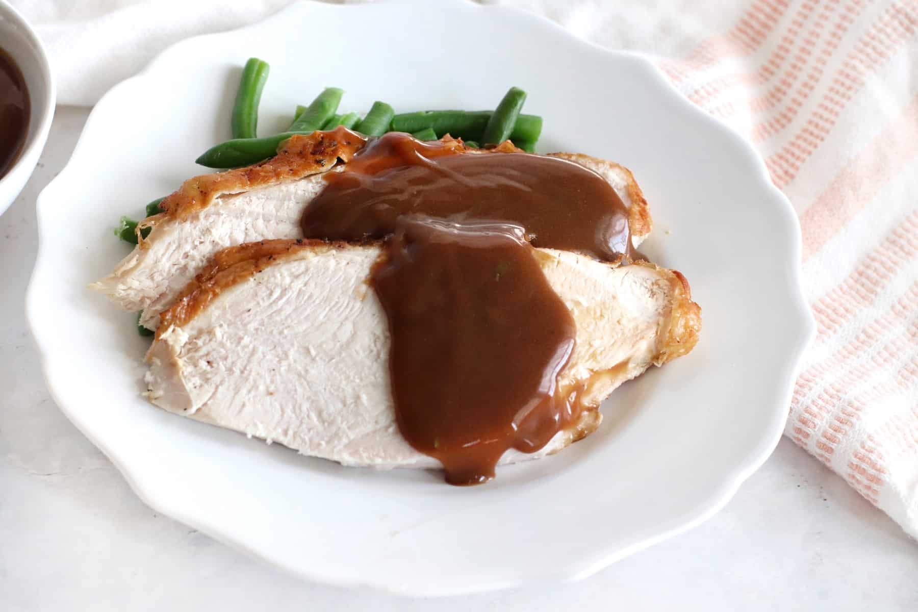 Sliced turkey with gravy over green beans