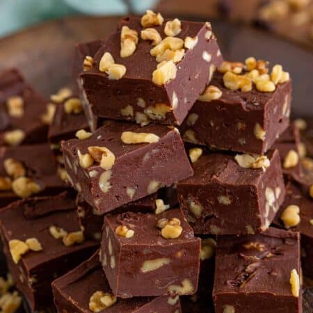 Chocolate Walnut Fudge cut in squares and piled on a plate.