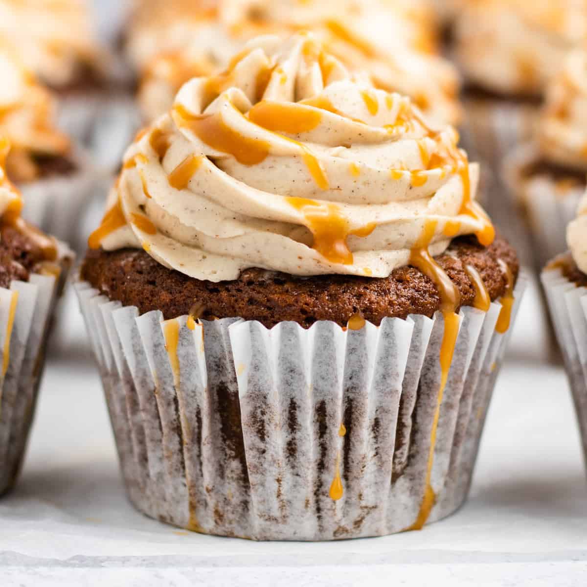 Square photo of a close-up of a gingerbread cupcake. 