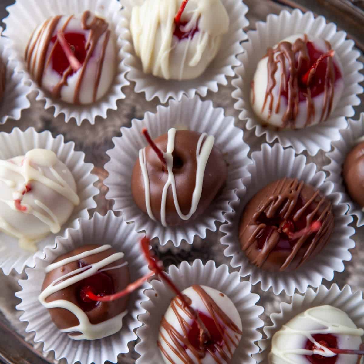 Overhead of chocolate covered cherries in candy paper cups. 