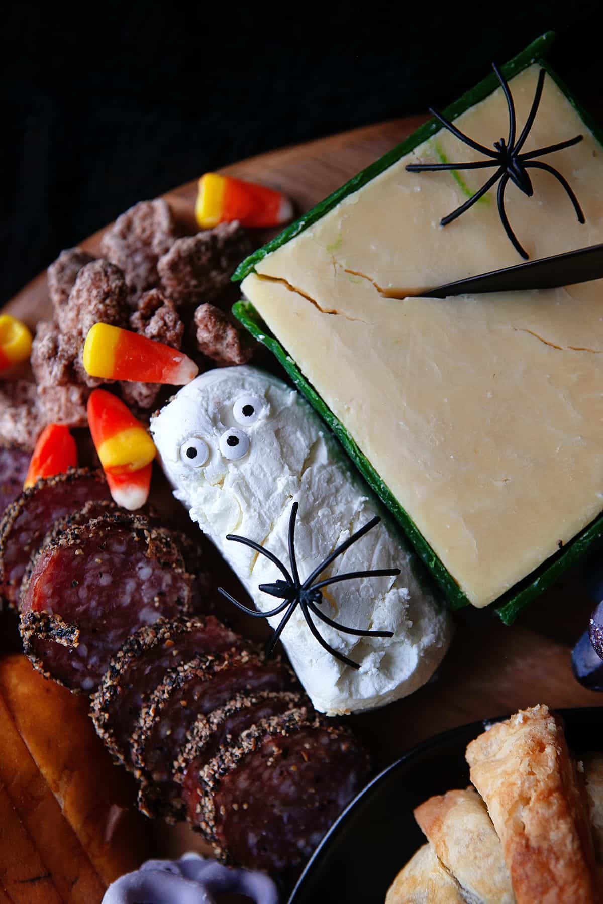 Cheese and meats from the Halloween cheese board with plastic spiders and eyeballs. 