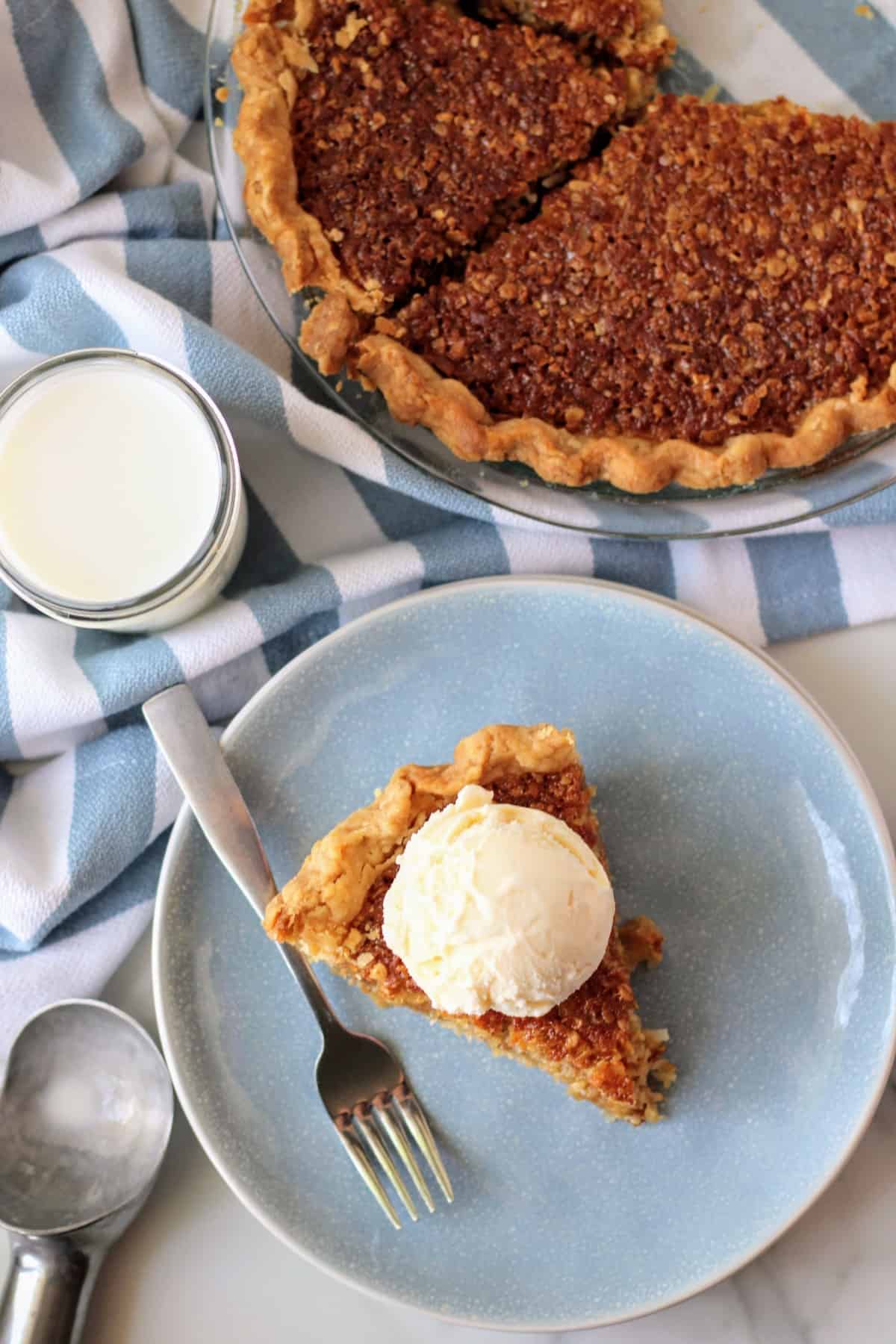 Overhead of pie on a plate with ice cream and the full pie in a pie plate. 