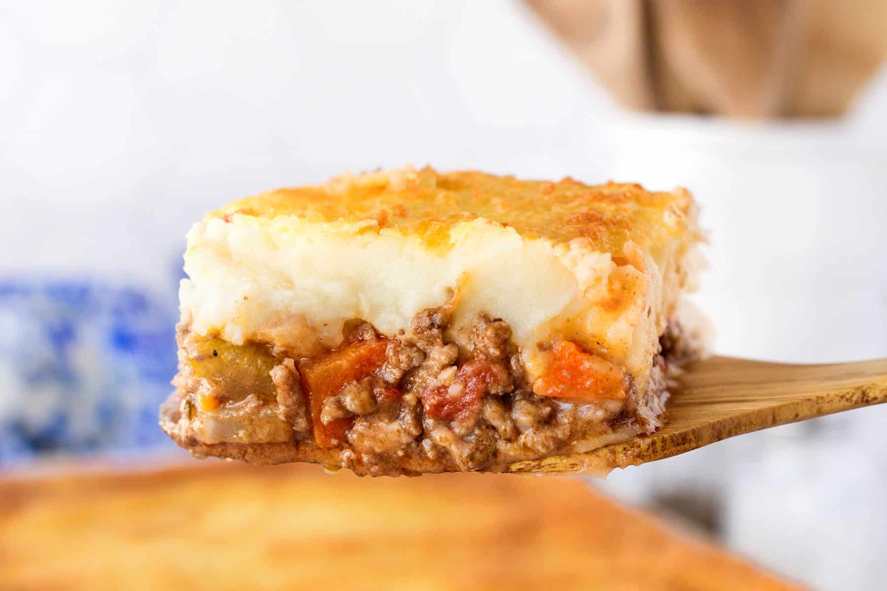 Serving of cottage pie on a large wooden paddle. 
