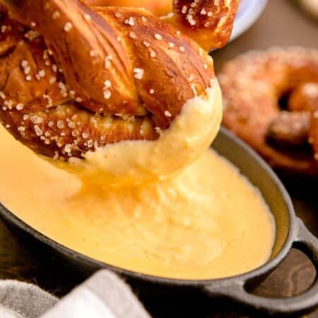 Dipping a soft pretzel into cheese sauce.