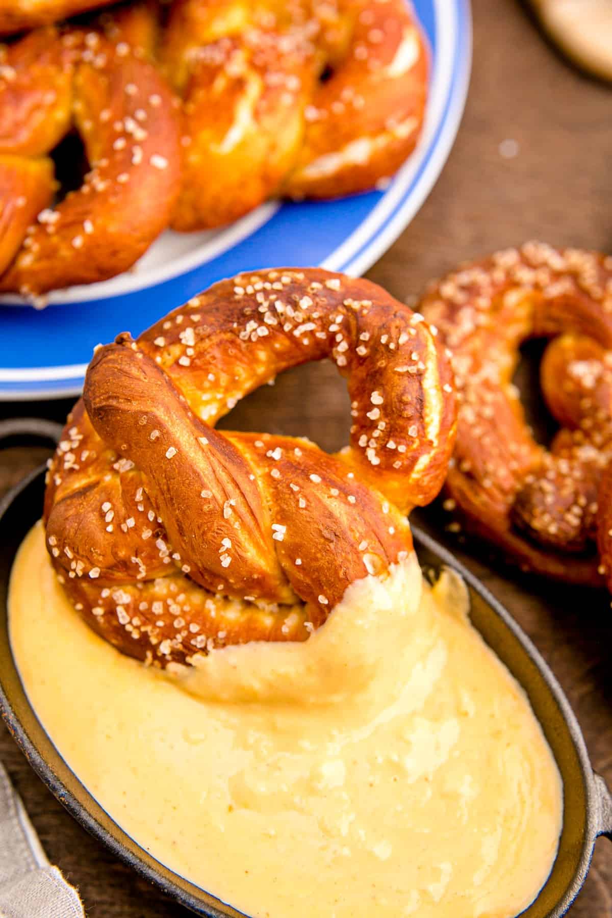 Soft pretzel dipping into cheese dip