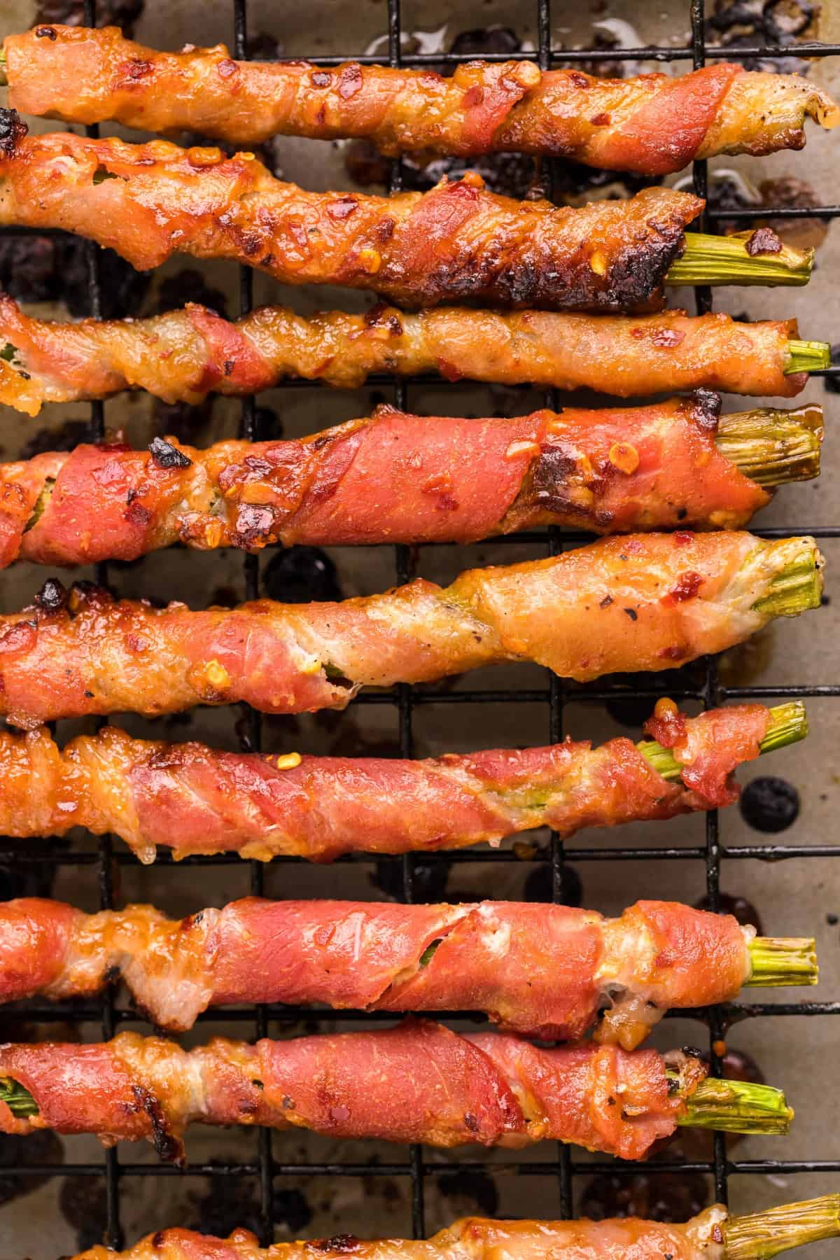 Bacon Wrapped Asparagus on a baking rack over a baking sheet. 