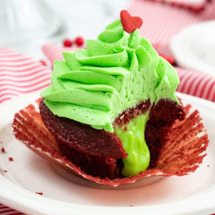 Showing the ooey gooey inside of a Grinch Cupcake with green pudding oozing out.