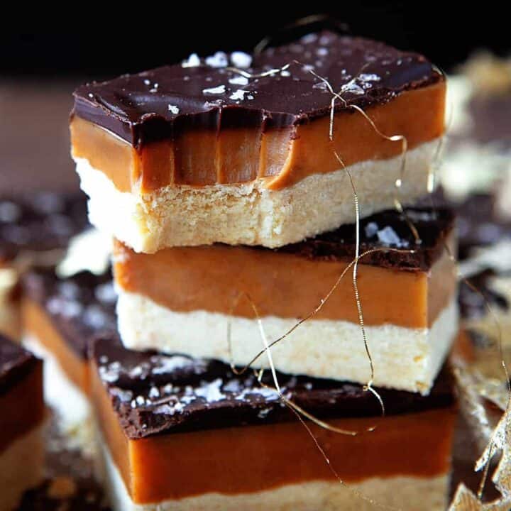 Millionaire Shortbread stacked and the top one has a bite taken