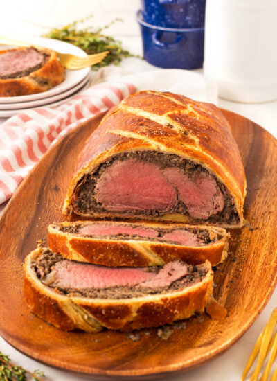 Perfect Beef Wellington sliced on a wooden board.