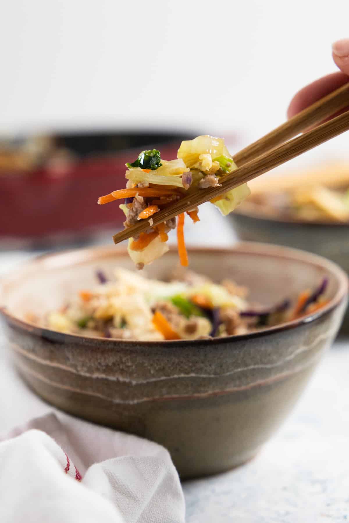 close up of chopsticks holding cooked slaw
