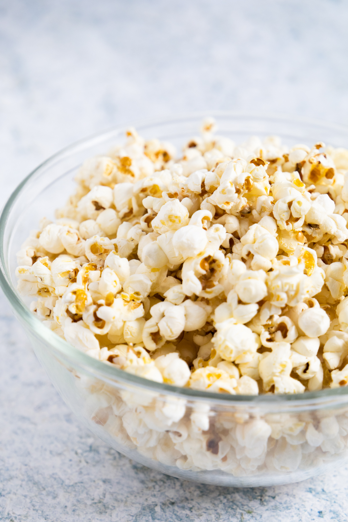 side view of plain popcorn in a transparent bowl